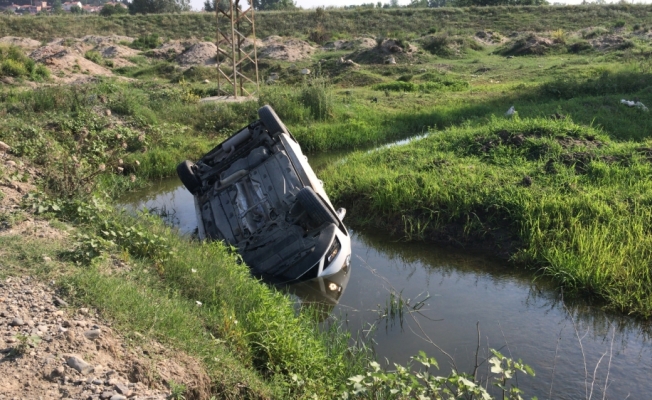 Su kanalına devrilen araçtan yara almadan kurtuldu